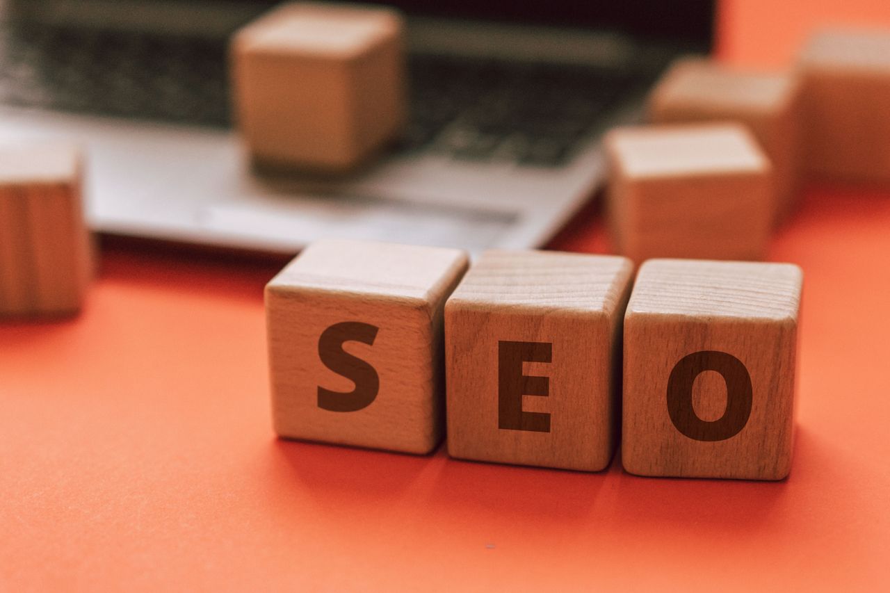 Crafting Captivating Headlines: Your awesome post title goes here Wooden blocks spelling SEO on a laptop keyboard convey digital marketing concepts.